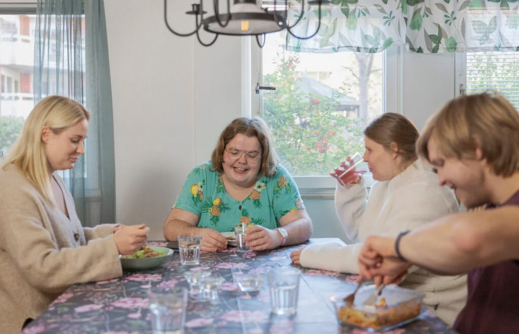 personer sitter och äter runt matbord